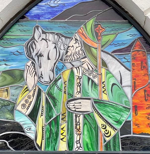 Stained glass window depicting St Colmcille holding a staff